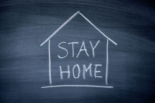 Stay at Home sign write on black chalkboard , prevent COVID-19 corona virus  spreading