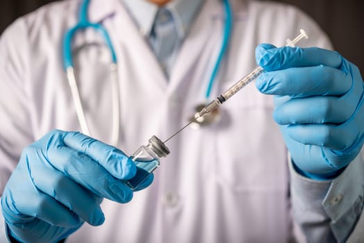 doctor hand holding blue vaccine bottle