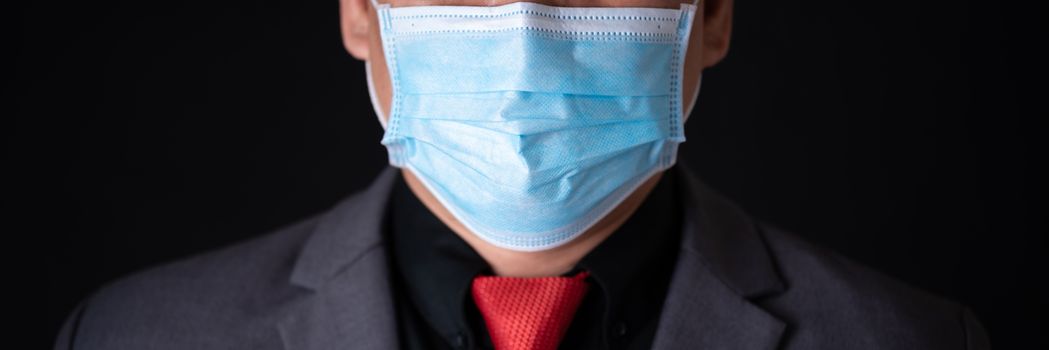 closed up of businessman in suite wearing medical mask protect him self and other from infect virus
