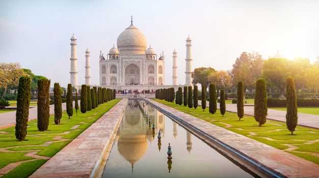 Sun rise at Taj Mahal front view reflected on the reflection pool, an ivory-white marble mausoleum on the south bank of the Yamuna river in Agra, Uttar Pradesh, India.