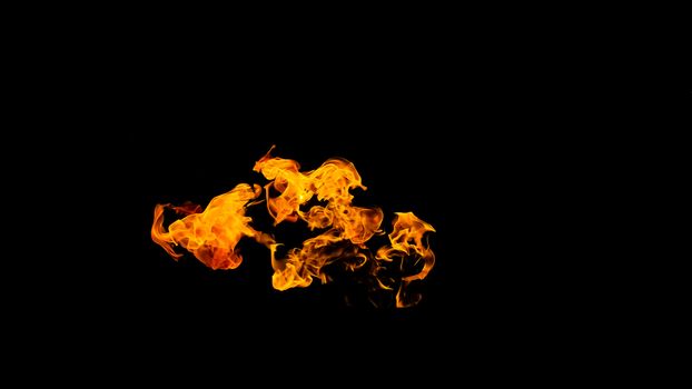 Fire flames on black background isolated. Burning gas or gasoline burns with fire and flames. Flaming burning sparks close-up, fire patterns. Infernal glow of fire in the dark with copy-space