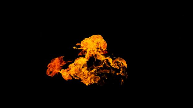 Fire flames on black background isolated. Burning gas or gasoline burns with fire and flames. Flaming burning sparks close-up, fire patterns. Infernal glow of fire in the dark with copy-space