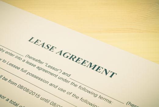 Lease Agreement Contract Document Left Angle View on Wood Table in Vintage Style. Legal document for business event