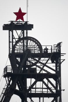 silhouette colliery coal mine with wheels and soviet star against the sky