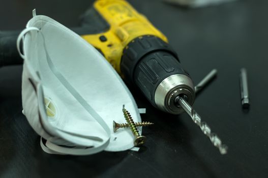 drill, respirator and screws on the table