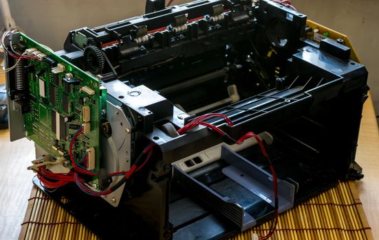 laser printer disassembled with the wires and the motherboard