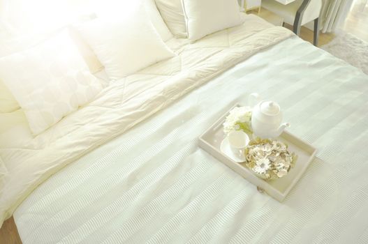 Bed maid-up with clean white pillows and bed sheets in luxury room. Close-up. Lens flair in sunlight.