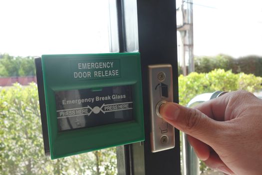 Man fingure is pressing /opening the emergency fire exit door.                              