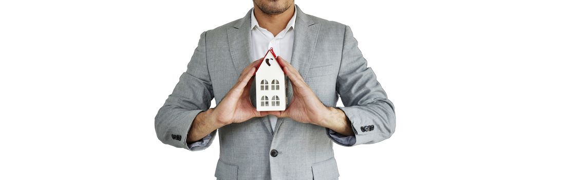 Home Concept : A man holding white mock up home on his hand for sale with  Copy space. Real estate agent with house model at Metal. Love home. New house. Renovate. Construction Building. Housing loan. Mortgage. Financial Agent. Property Investment. House Mortgage.