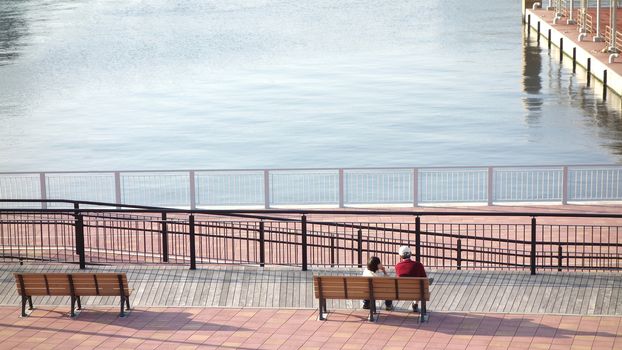 Couple siting see view at river in Japan. Beautiful happy young couple in love, siting on the bench. 