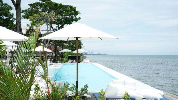 Swimming pool and cafe bar near the beach. Luxury cafe restaurant on Swimming pool bar at the seaside blue ocean.