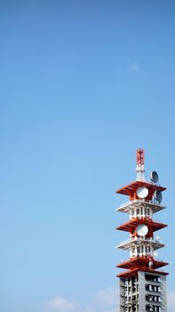 Telecommunication Tower in Tokyo, Japan . Cell Phone Signal Tower on blue sky background. Communication tower on blue sky. top of a cellular repeater tower. Cell tower white against a blue sky background. Copy space                               