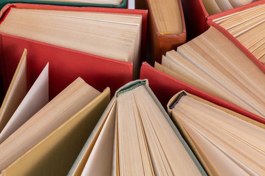 Many different old hardcover physical books close-up background with selective focus and blur.