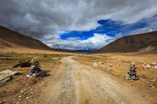 Road in Himalayas with stone cairns. Ladakh, Jammu and Kashmir, India
