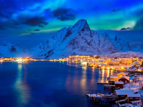 Reine village illuminated at night with Aurora Borealis. Lofoten islands, Norway