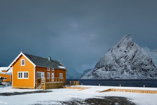 Yellow traditional rorbu house in Sakrisoy fishing village in winter on Lofoten Islands, Norway