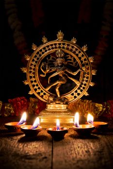 Maha Shivaratri or Diwali concept - Shiva Nataraja figurine with Diwali lights oil ghee candles, India