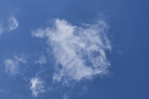 Background of a one single cumulus cloud with a blue clear sky