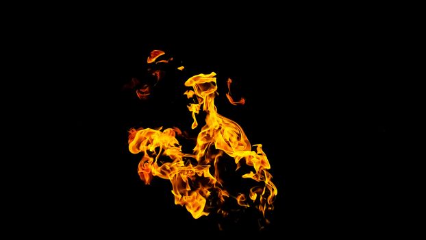 Fire flames on black background isolated. Burning gas or gasoline burns with fire and flames. Flaming burning sparks close-up, fire patterns. Infernal glow of fire in the dark with copy-space