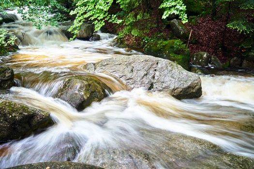 Rocks and boulders in the mountain stream in the forest in the Giant Mountains in Poland