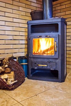 Flames of fire in a cast-iron stove in a corner of the room in Poland