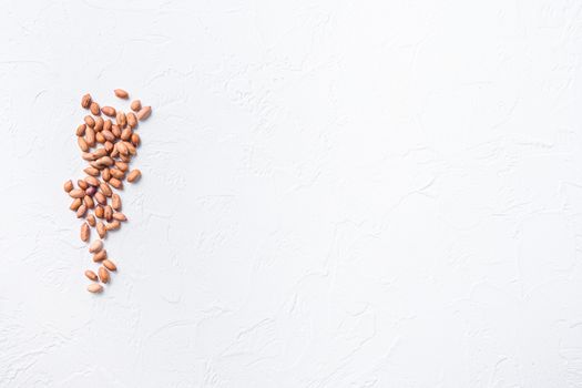 peeled peanuts on white concrete textured background top view space for text