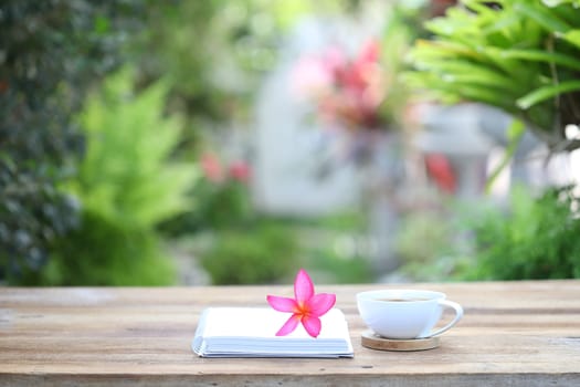 Books with flowers and cup on wooden table