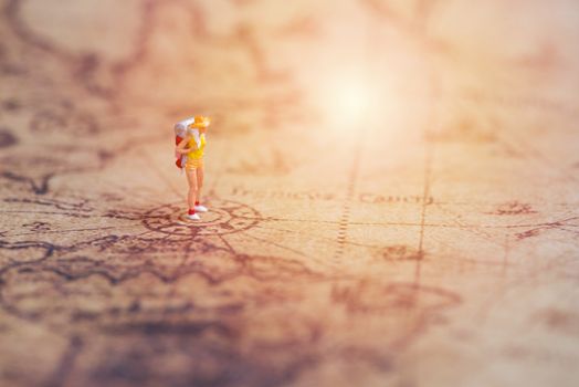 miniature traveler on vintage world map