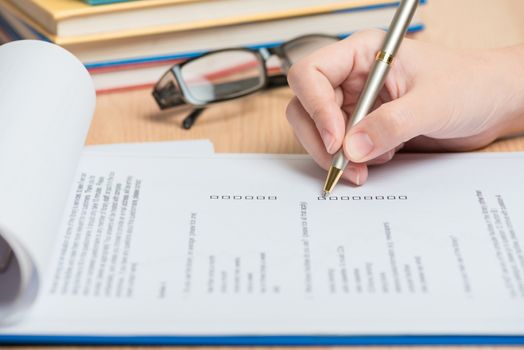 woman hand holding a pen correct the check list question in insurance form.