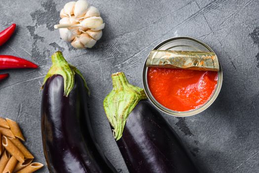 Tomatoe sauce canned ingredients eggplant pasta, pepper tomatoe sauce, on grey background top view selective focus