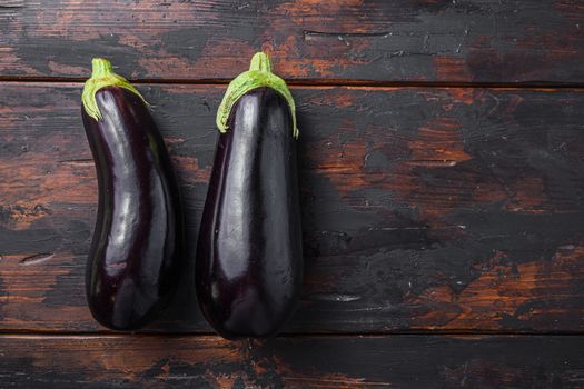 Fresh healthy raw Purple aubergine on a kitchen old dark wooden table. Top view, space for text