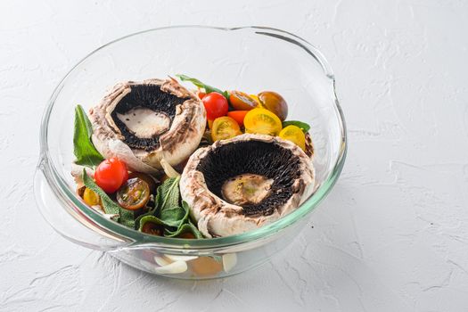 Portobello and ingredients for baking cheddar cheese, cherry tomatoes and sage in glass pot on white background side view space for text