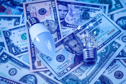 LED lamp and bulb on dollar bills background. The concept of saving money on electricity.