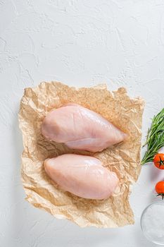 Fresh raw organic chicken fillet, spices and herbs on white concrete background, top view.