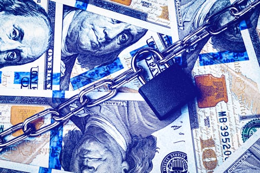 Dollar bills, black lock and metal chain. Money lock or security concept. Account lockout. 