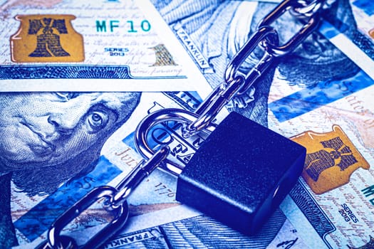 Dollar bills, black lock and metal chain. Money lock or security concept. Account lockout. 