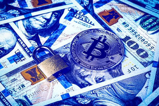 Dollar bills, yellow lock and metal souvenir bitcoin. The concept of virtual money, online trading, mining and commerce. Electronic wallet blocking. Cryptocurrency and cash.