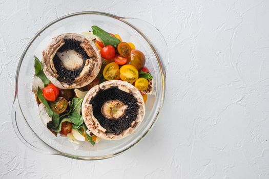 Portobello and ingredients for baking cheddar cheese, cherry tomatoes and sage in glass pot on white background top view concept framed space for text