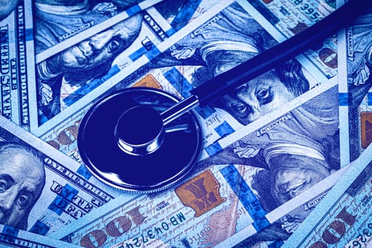 Stethoscope on the background of one hundred dollar bills. The concept of the expensive cost of healthcare or financing medicine.