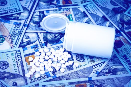 Heart-shaped pills on the background of hundred-dollar bills. The concept of the expensive cost of healthcare or financing medicine. White medicine bottle with copy space for text.