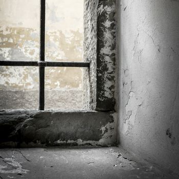 Old grunge prison with sun rays breaking through a barred window. Shallow DOF.