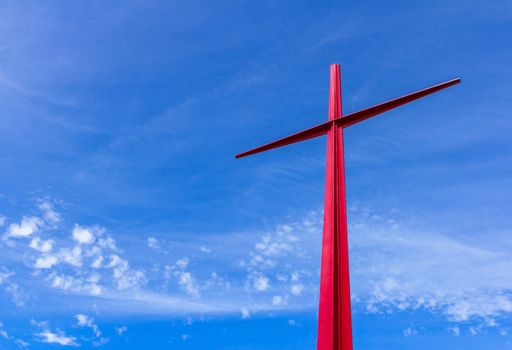 Large red christian cross on sky background. Passion symbology. Easter.