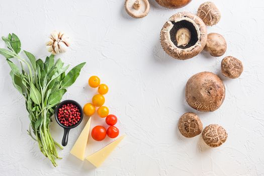 Ingredients for baking portobello, cheddar cheese, cherry tomatoes and sage on white background top view concept framed space for text