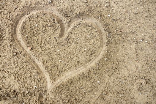 Drawing a heart on the wet sand at the sea. Top view. Ideal for concepts and background. Saint Valentine's day.