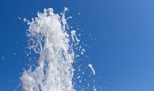 Stream of water from fountain against the blue sky