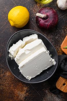 Traditional feta cheese in black bowl top view