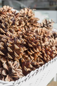 Wicker basket filled with pine cones. Close up. Shallow depth of field.