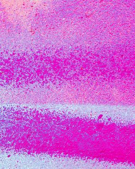 Fragment of colorful graffiti painted on a concrete wall. Bright pink or purple abstract background for design.