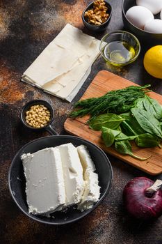 Traditional greek spanakopita ingredients filo spinach eggs feta side view on dark background