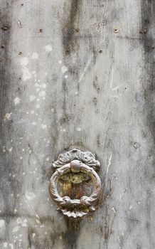 Ancient door knocker on white vintage background.